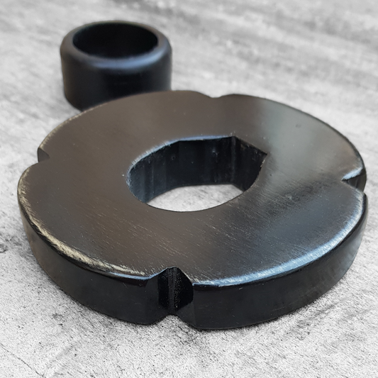 A black and brown wooden tsuba for bokken, displayed with a rubber stopper.