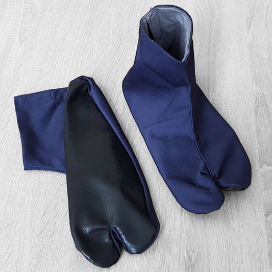 A pair of blue Tabi shoes with hook and loop fasteners, designed for martial arts practice on tatami.