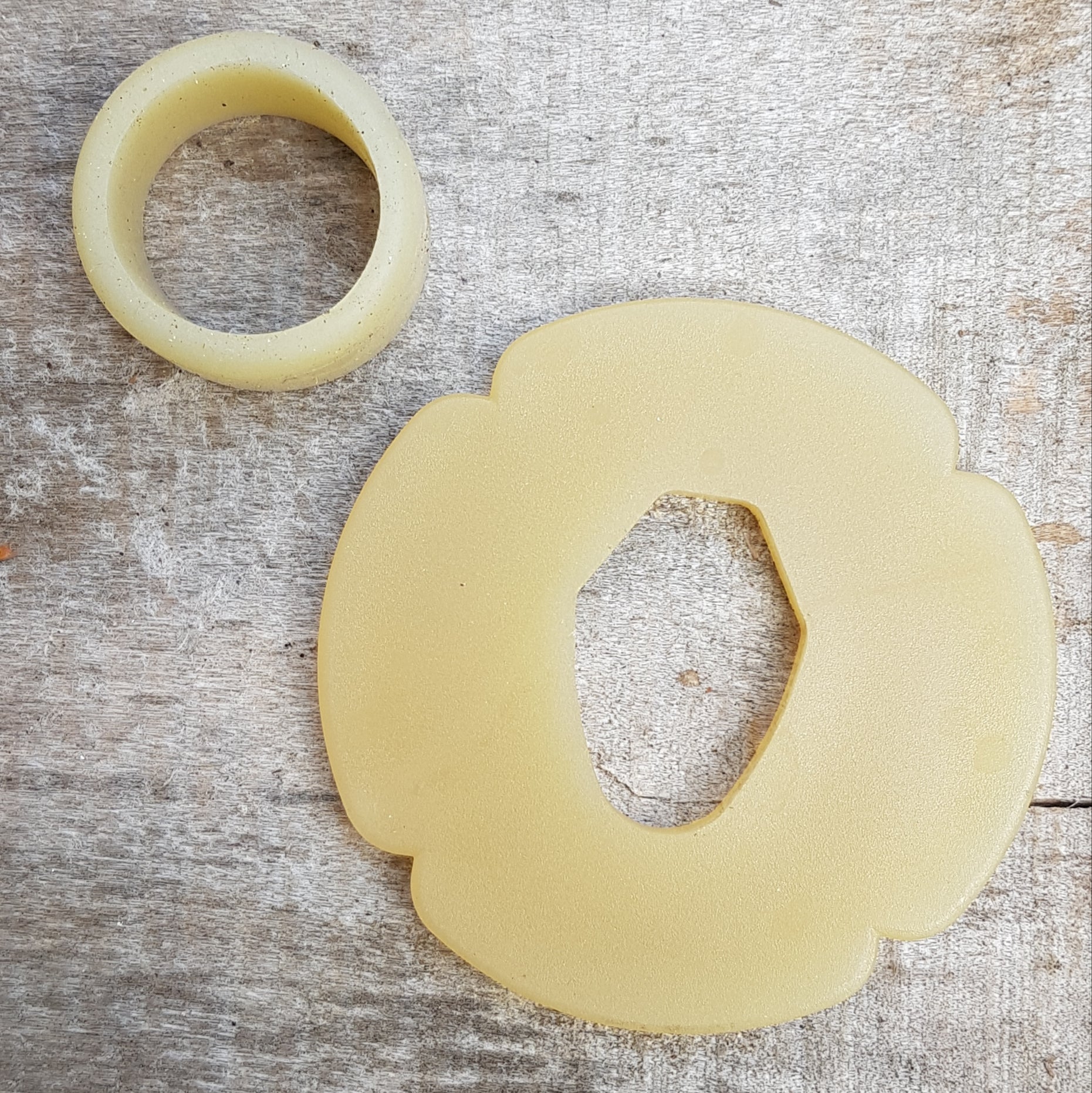 A set of plastic tsuba in black, brown, and beige colors, designed for use with wooden bokken in fencing. The tsuba are in various sizes and shapes, with a four-leaf petal form for protecting the hand.