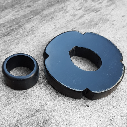 A black and brown wooden tsuba for bokken, displayed with a rubber stopper.