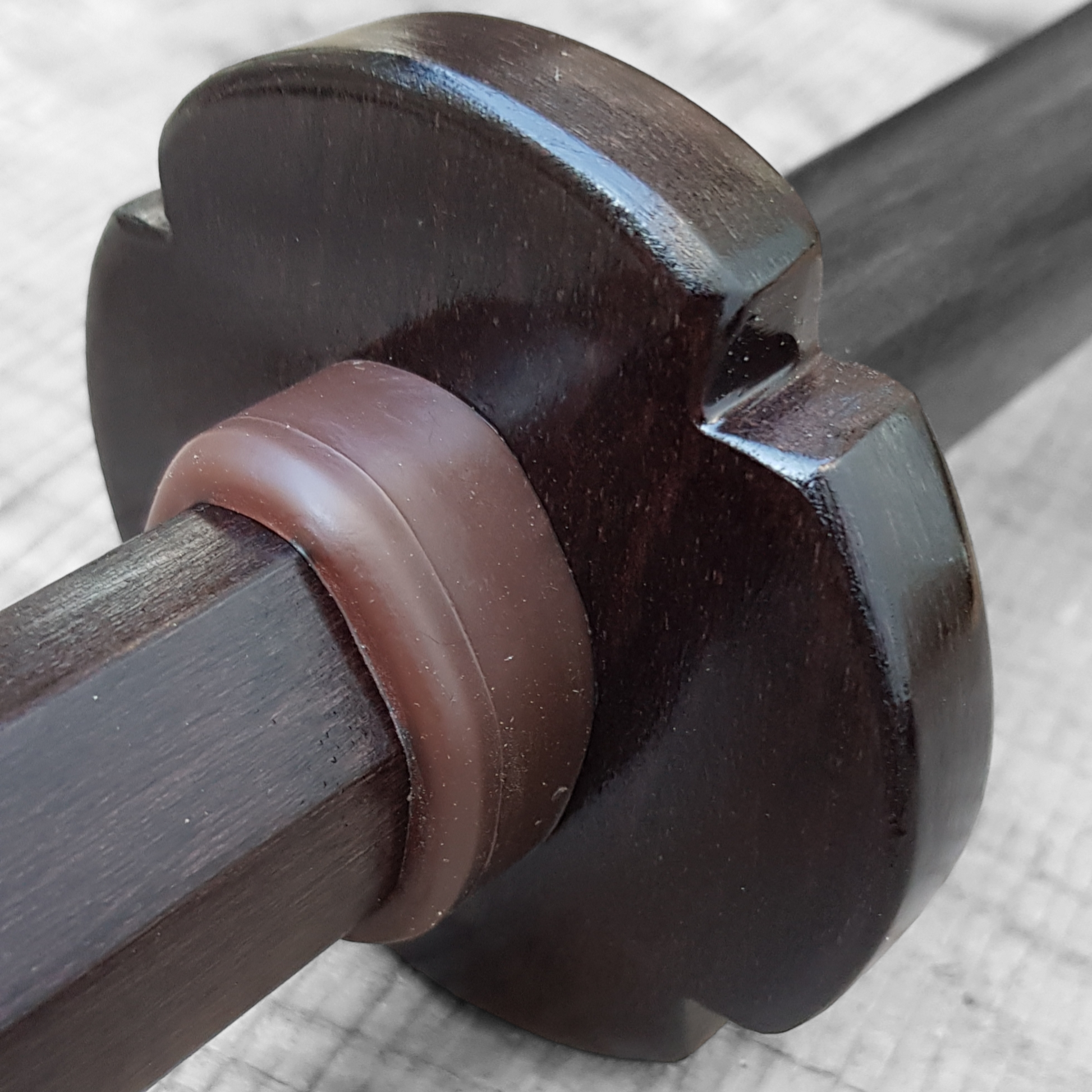 Wooden tsuba for bokken, displayed with a rubber stopper.